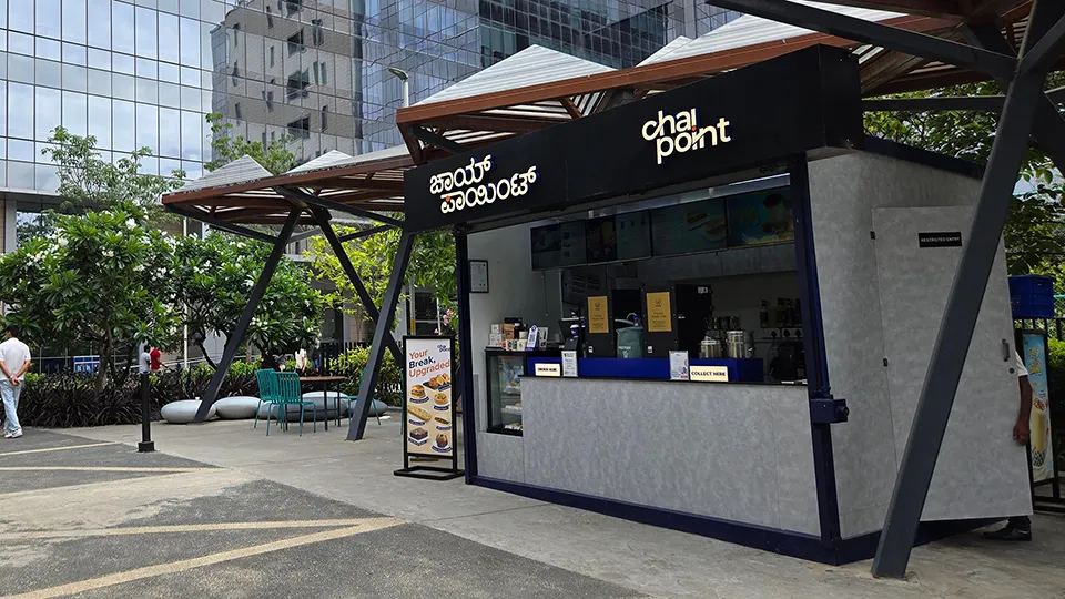 A modular Chai Point kiosk store on a landscaped office plaza